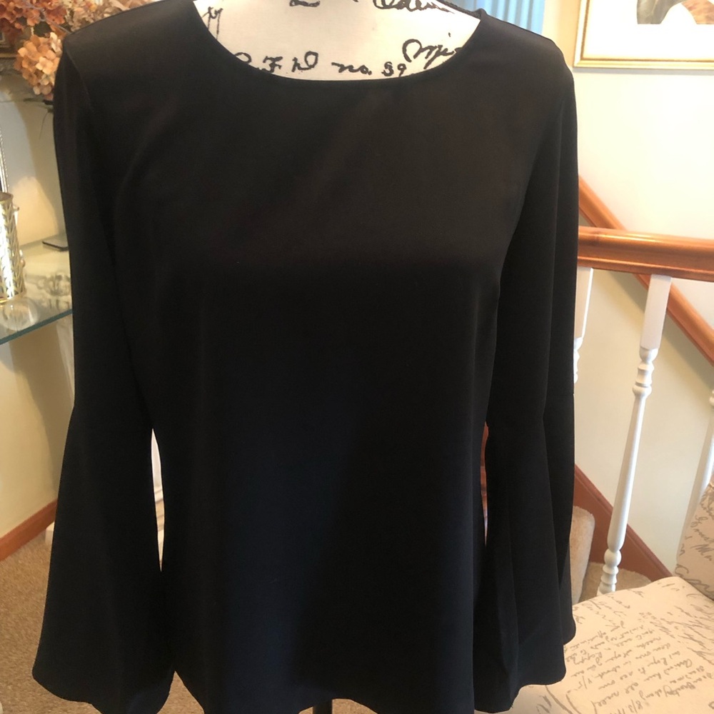 Lines black top with bell sleeves with open detail in back.